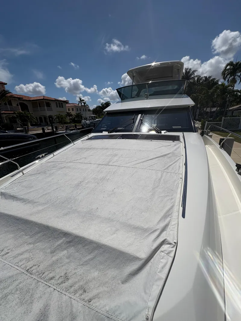 Slide: The Image of 2018 Prestige 680 yacht docked under a clear blue sky, showcasing sleek design and luxury features. - 33