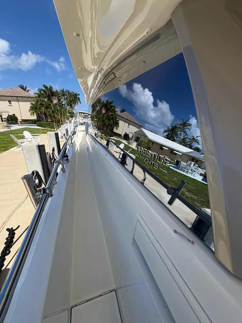 Slide: The Image of 2018 Prestige 680 yacht docked, reflecting clear blue sky and palm trees. - 34