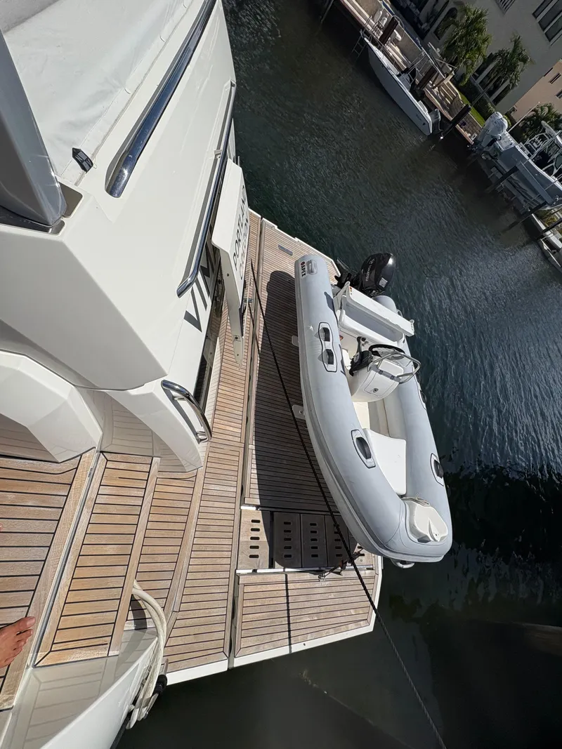 Slide: The Image of Prestige 680 yacht with inflatable boat on deck, docked in marina, 2018 model. - 35