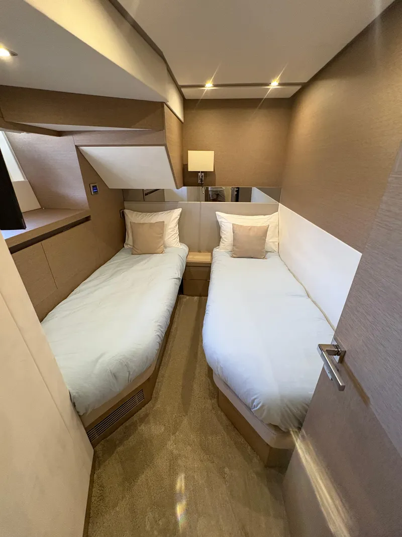 Slide: The Image of Twin bedroom in 2018 Prestige 680 yacht with modern decor and cozy lighting. - 41