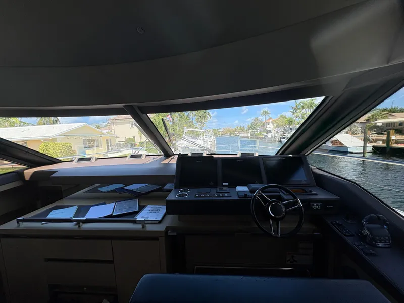 Slide: The Image of Interior view of 2018 Prestige 680 yacht cockpit with navigation equipment and waterfront scenery. - 47