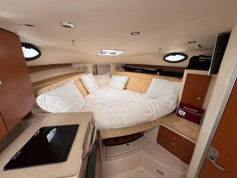 Slide: The Image of 2006 Wellcraft 290 Coastal cabin interior with cozy bed and compact kitchen area. - 13