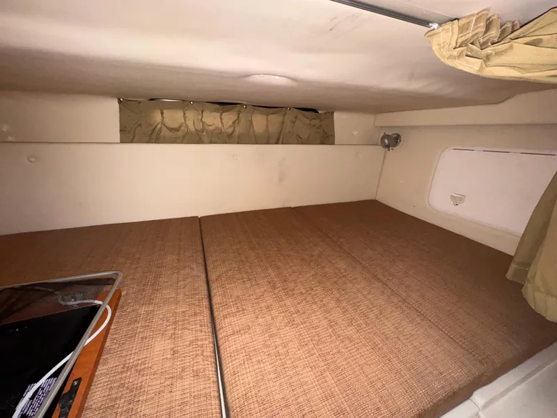 Slide: The Image of 2006 Wellcraft 290 Coastal cabin interior with beige upholstery and compact sleeping area. - 15