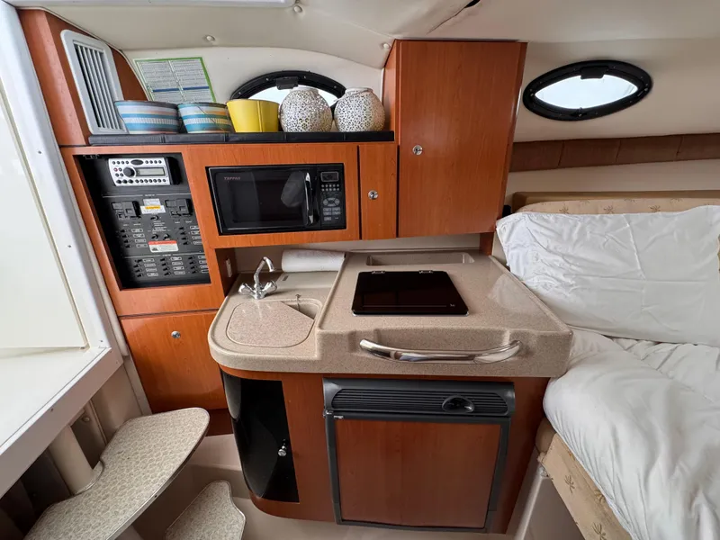 Slide: The Image of 2006 Wellcraft 290 Coastal cabin interior with kitchenette, microwave, and cozy sleeping area. - 16