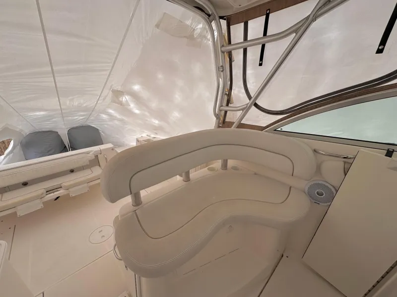 Slide: The Image of 2006 Wellcraft 290 Coastal boat interior with beige seating and protective cover. - 21