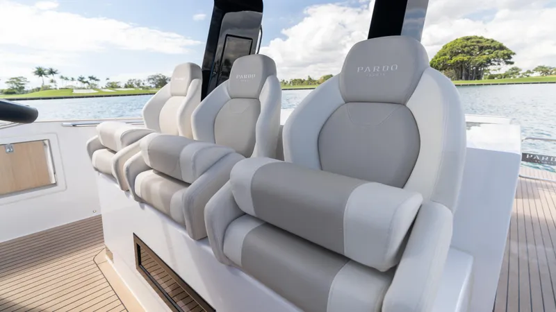 Slide: The Image of 2025 Pardo Yachts 38 interior with luxurious seating, overlooking serene water and lush greenery. - 19