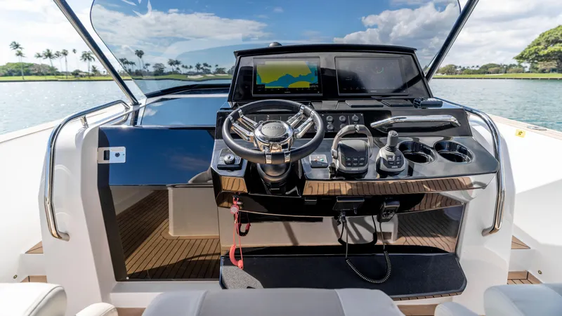 Slide: The Image of 2025 Pardo Yachts 38 helm with modern controls and navigation, set against a scenic water backdrop. - 23