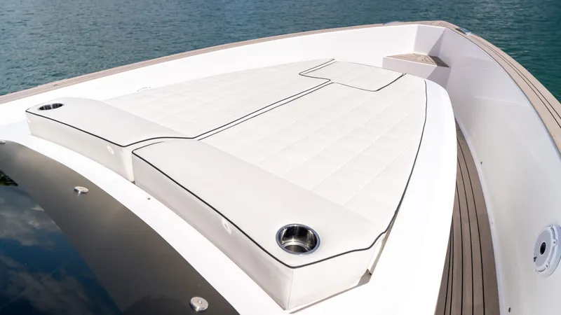 Slide: The Image of 2025 Pardo Yachts 38 deck with cushioned seating, sleek design, and ocean backdrop. - 26