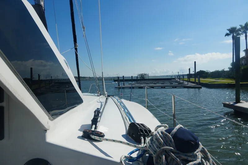 Slide: The Image of Sailboat Gemini 105M, 1997 model, docked in sunny marina with clear blue sky. - 12