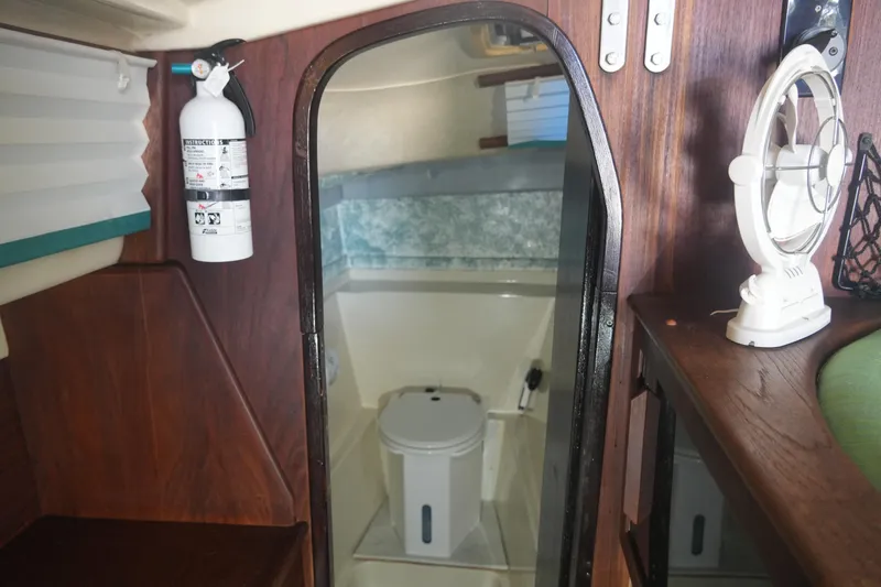 Slide: The Image of Interior of 1997 Gemini 105M boat with toilet, fire extinguisher, and fan. - 17