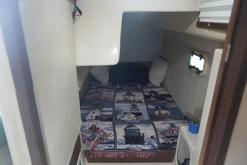 Slide: The Image of Cozy cabin interior of 1997 Gemini 105M sailboat with lighthouse-themed bedding. - 19