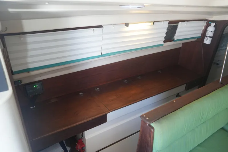 Slide: The Image of Interior of a 1997 Gemini 105M boat with wooden desk and green seating. - 20