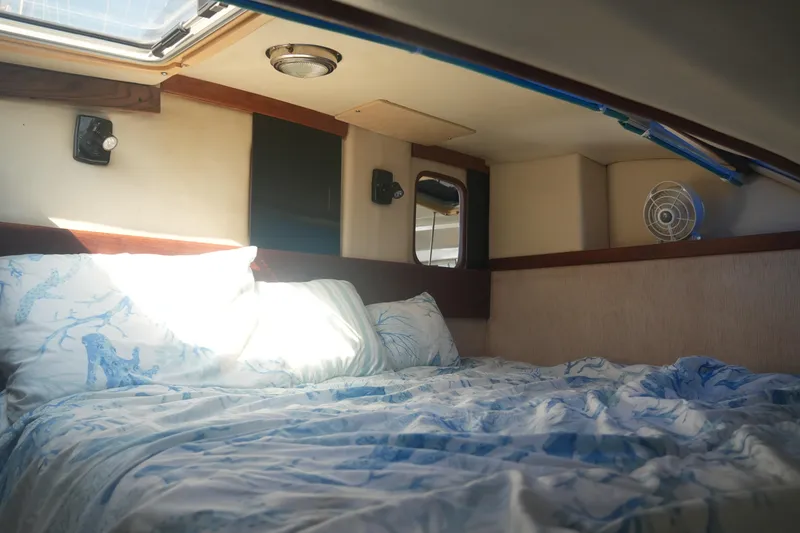 Slide: The Image of Cozy cabin interior of a 1997 Gemini 105M sailboat with bedding and natural light. - 23