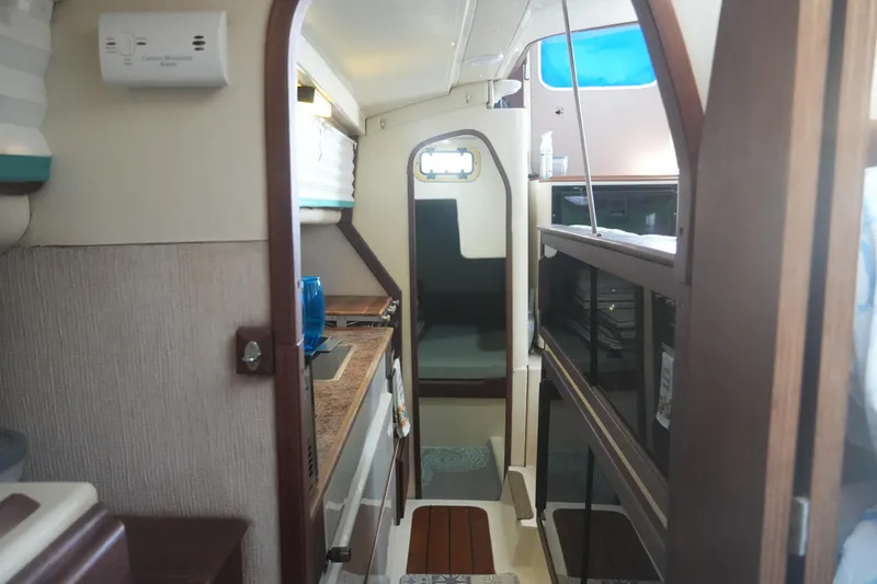 Slide: The Image of Interior of a 1997 Gemini 105M sailboat, featuring a compact kitchen and cozy cabin space. - 26
