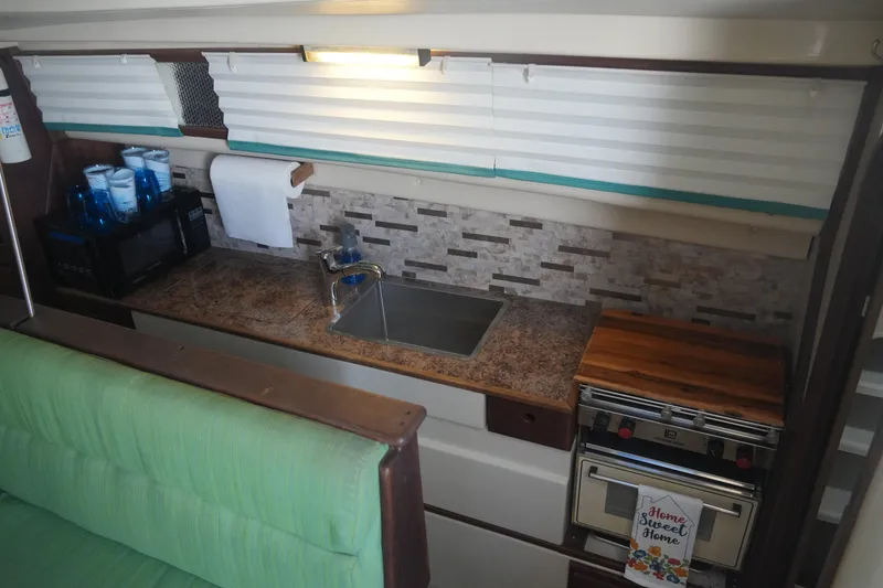Slide: The Image of Compact kitchen in a 1997 Gemini 105M boat with sink, stove, and microwave. - 27