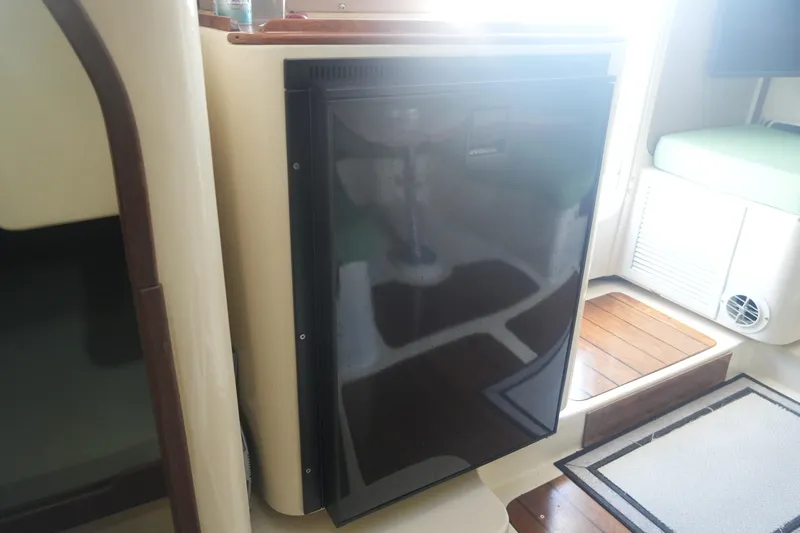 Slide: The Image of Interior of 1997 Gemini 105M yacht featuring a compact black refrigerator. - 28