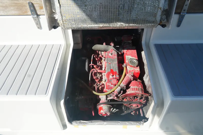 Slide: The Image of Engine compartment of a 1997 Gemini 105M sailboat, featuring a red marine engine. - 29