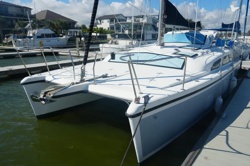 Slide: The Image of 1997 Gemini 105M catamaran docked at marina, featuring sleek design and spacious deck. - 5