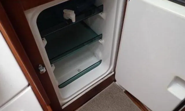 Slide: The Image of Beneteau Oceanis Clipper 361 (2002) interior fridge with open door and glass shelves. - 18