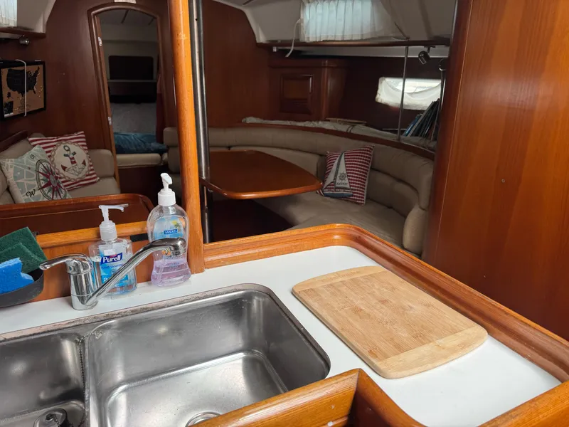 Slide: The Image of Interior of 2002 Beneteau Oceanis Clipper 361 yacht with kitchen and seating area. - 25