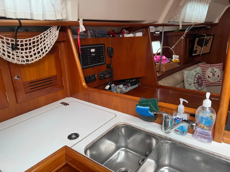 Slide: The Image of Interior of 2002 Beneteau Oceanis Clipper 361 yacht, featuring a compact kitchen area. - 26