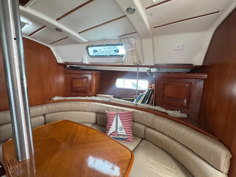 Slide: The Image of Interior of 2002 Beneteau Oceanis Clipper 361 sailboat with cozy seating and wooden table. - 27