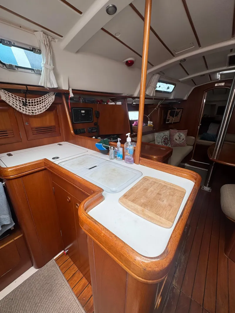 Slide: The Image of 2002 Beneteau Oceanis Clipper 361 yacht interior with wooden cabinetry and kitchen area. - 28