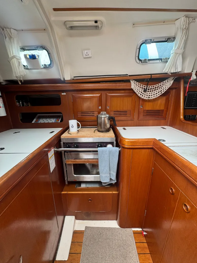 Slide: The Image of Interior of 2002 Beneteau Oceanis Clipper 361 yacht kitchen with wood cabinetry and appliances. - 29