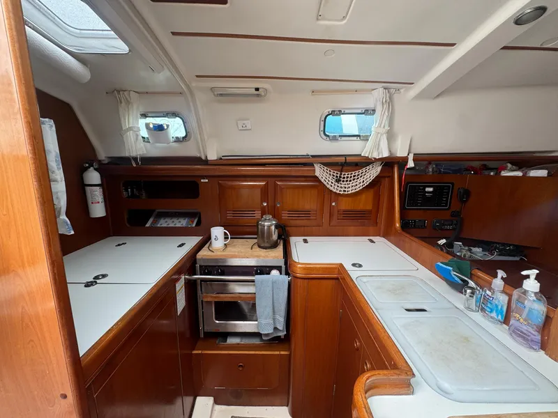 Slide: The Image of Interior of 2002 Beneteau Oceanis Clipper 361 yacht kitchen with wooden cabinetry and appliances. - 30