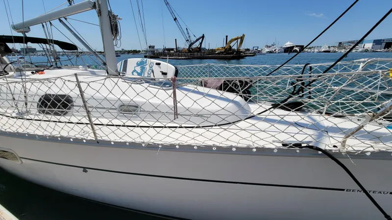 Slide: The Image of 2002 Beneteau Oceanis Clipper 361 sailboat docked in a marina, with cranes in the background. - 5