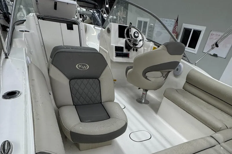 Slide: The Image of 2025 Key West 203DFS boat interior with gray seating and steering console. - 5