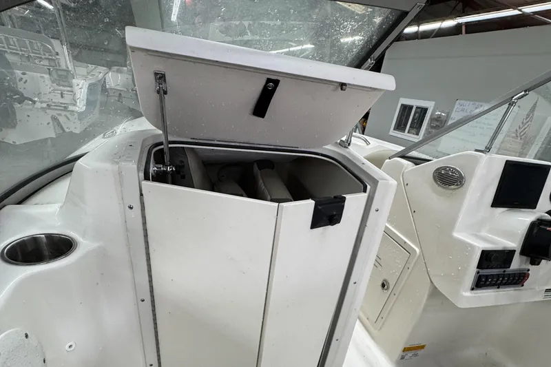 Slide: The Image of 2025 Key West 203DFS boat storage compartment with open lid, showcasing interior space. - 7