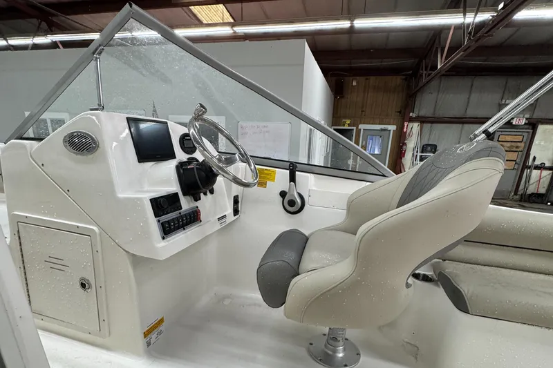 Slide: The Image of 2025 Key West 203DFS boat interior with steering wheel and captain's chair. - 8