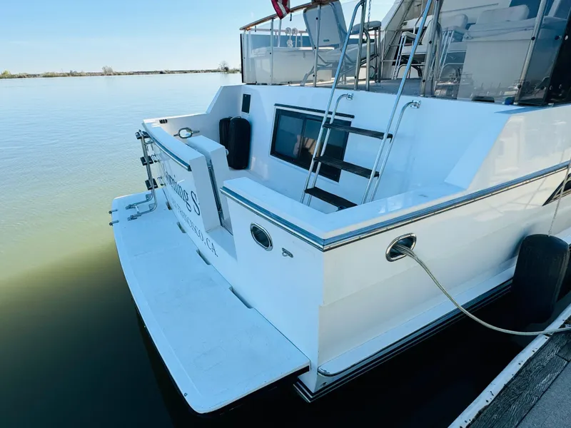 Slide: The Image of 1991 Ocean Alexander 440 Sundeck CPMY yacht docked on calm water. - 1