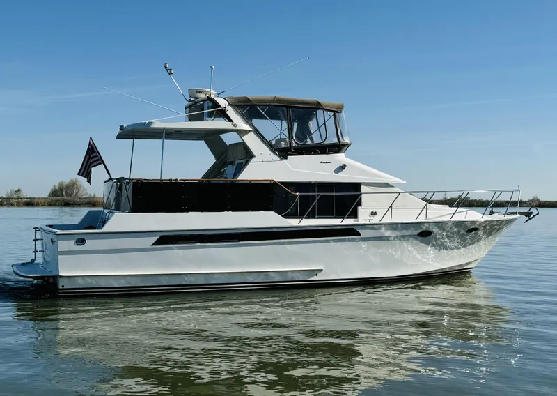 Slide: The Image of 1991 Ocean Alexander 440 Sundeck CPMY yacht on calm water under clear blue sky. - 10