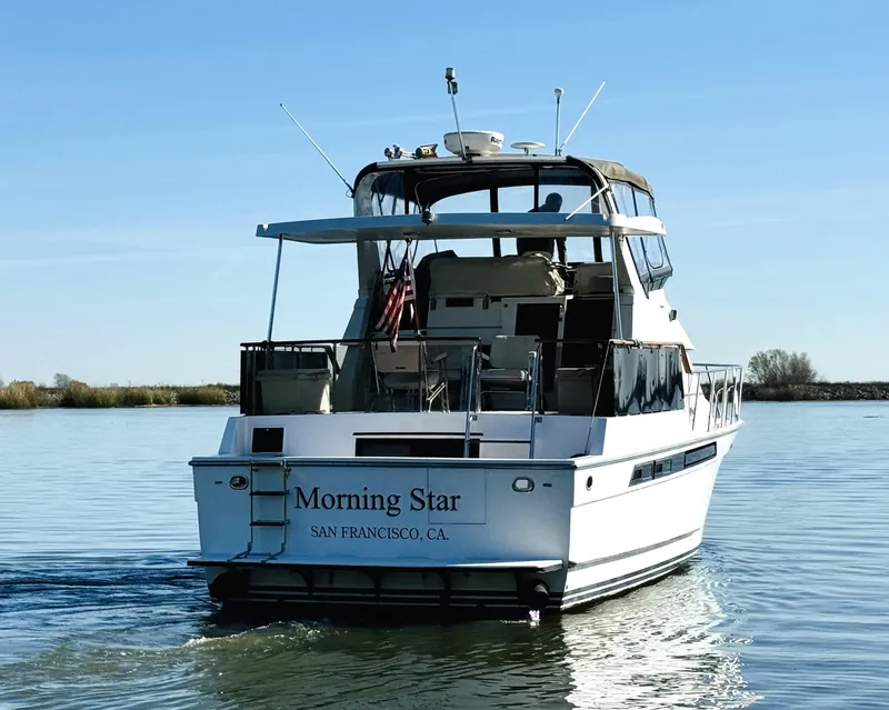 Slide: The Image of 1991 Ocean Alexander 440 Sundeck CPMY yacht on calm water, rear view. - 11