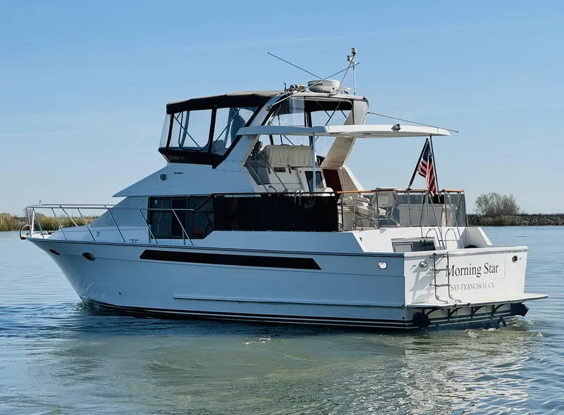Slide: The Image of 1991 Ocean Alexander 440 Sundeck CPMY yacht on calm water, rear view. - 13