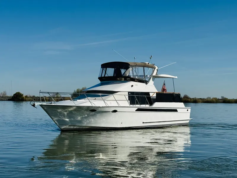 Slide: The Image of 1991 Ocean Alexander 440 Sundeck CPMY yacht on calm water under clear blue sky. - 16