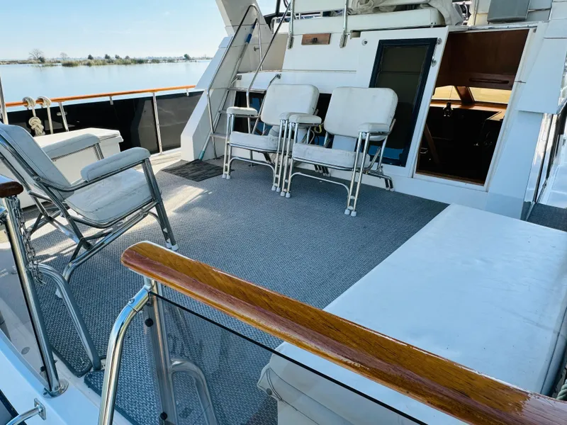 Slide: The Image of 1991 Ocean Alexander 440 Sundeck CPMY yacht deck with seating and railing, overlooking water. - 2