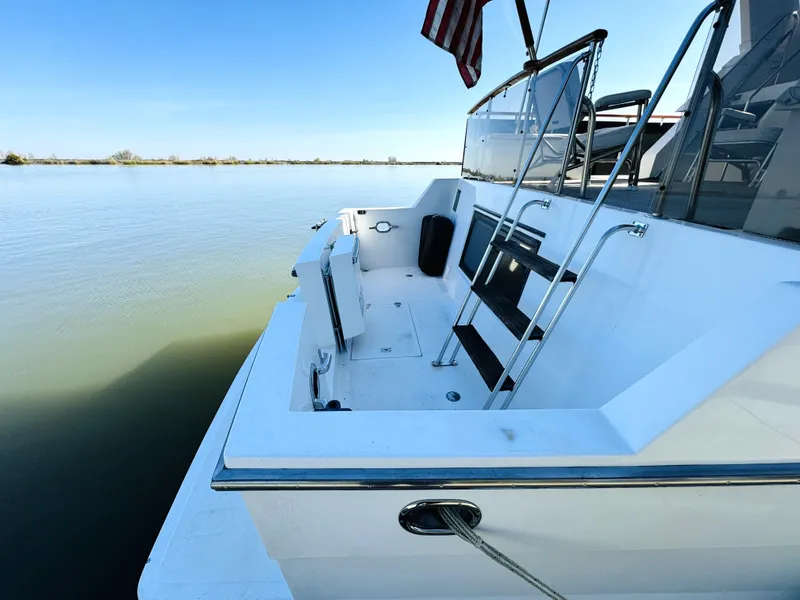 Slide: The Image of 1991 Ocean Alexander 440 Sundeck CPMY yacht on calm water, featuring sleek deck design. - 20