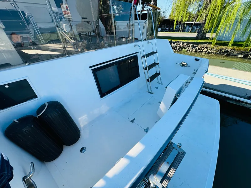 Slide: The Image of 1991 Ocean Alexander 440 Sundeck CPMY boat deck with ladder and dock view. - 21