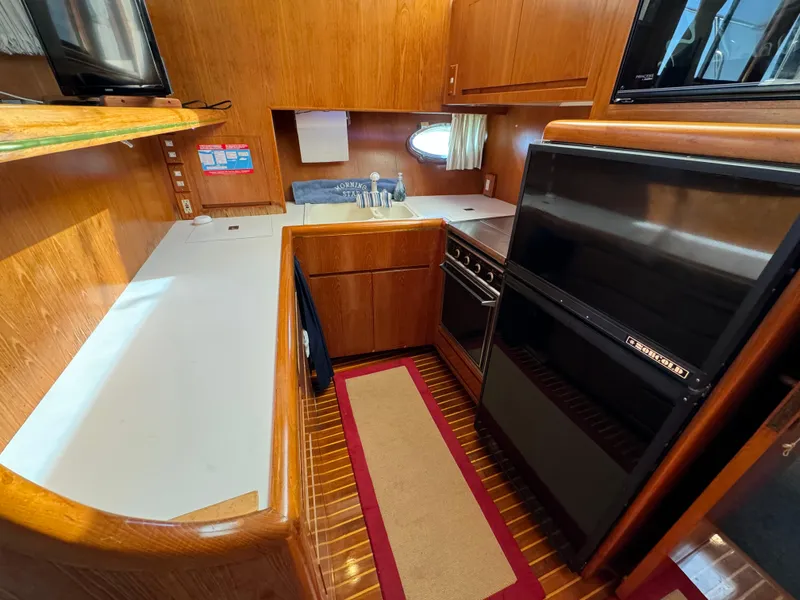Slide: The Image of 1991 Ocean Alexander 440 Sundeck CPMY kitchen with wood cabinetry and modern appliances. - 43