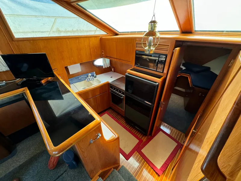 Slide: The Image of Interior of 1991 Ocean Alexander 440 Sundeck CPMY yacht, featuring kitchen and cozy cabin area. - 44
