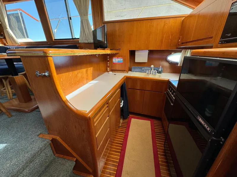 Slide: The Image of Interior of 1991 Ocean Alexander 440 Sundeck CPMY with wood cabinetry and modern appliances. - 45