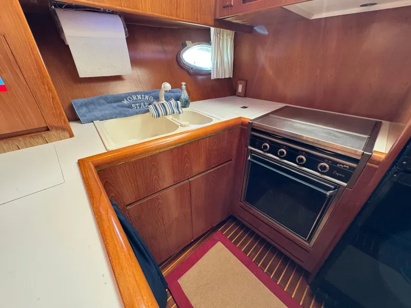 Slide: The Image of 1991 Ocean Alexander 440 Sundeck CPMY kitchen with wood cabinetry and compact stove. - 46