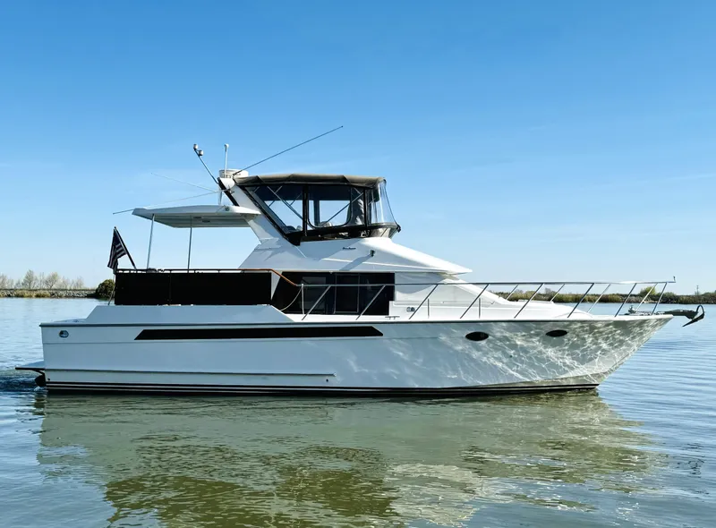 Slide: The Image of 1991 Ocean Alexander 440 Sundeck CPMY yacht on calm water under clear blue sky. - 6
