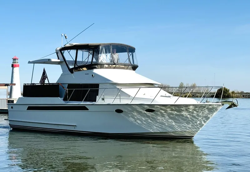 Slide: The Image of 1991 Ocean Alexander 440 Sundeck CPMY yacht on calm water near a lighthouse. - 7