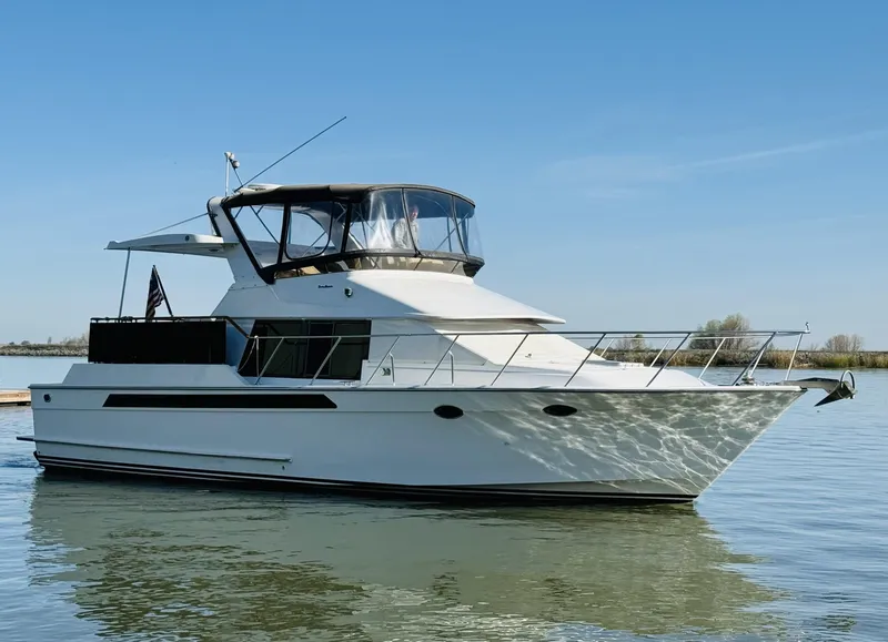 Slide: The Image of 1991 Ocean Alexander 440 Sundeck CPMY yacht on calm water under clear blue sky. - 8