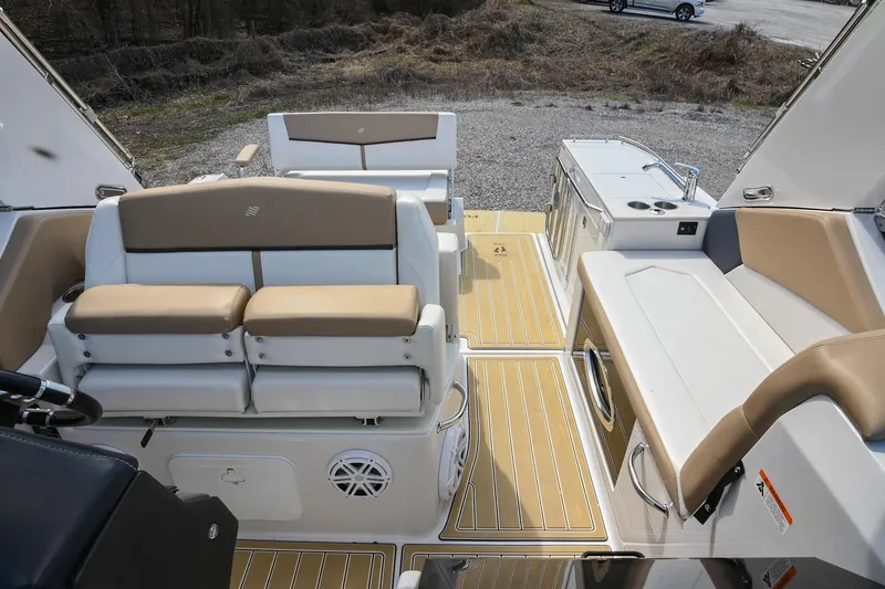 Slide: The Image of 2014 Four Winns V275 boat interior with beige seating and wood-style flooring. - 10