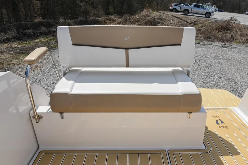 Slide: The Image of 2014 Four Winns V275 boat seat with beige and white upholstery, parked on gravel. - 12